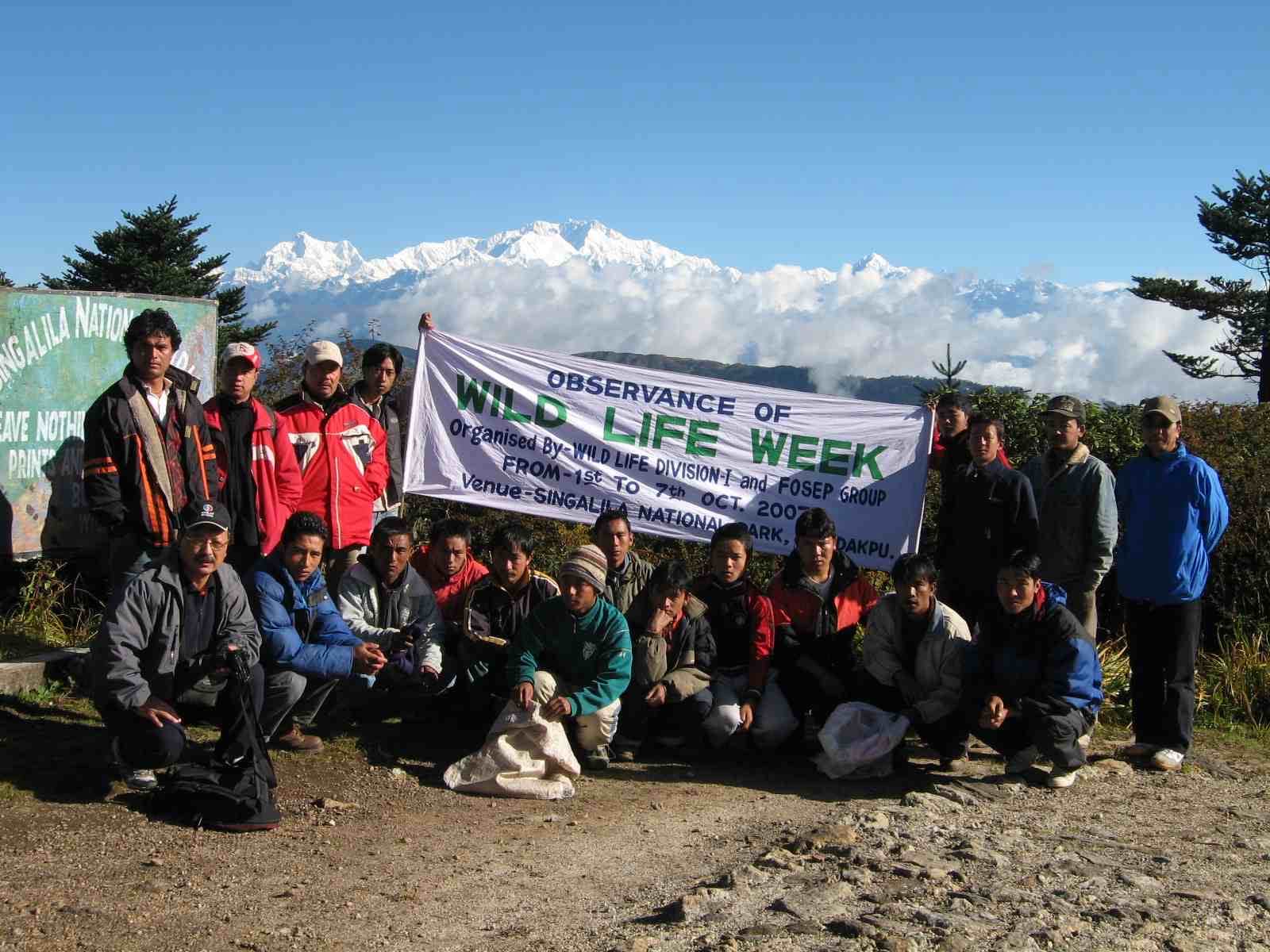 The FOSEP team gathered with a Wildlife Week banner at Singalila National Park, the snow peaks of Kanchenjunga rising behind them