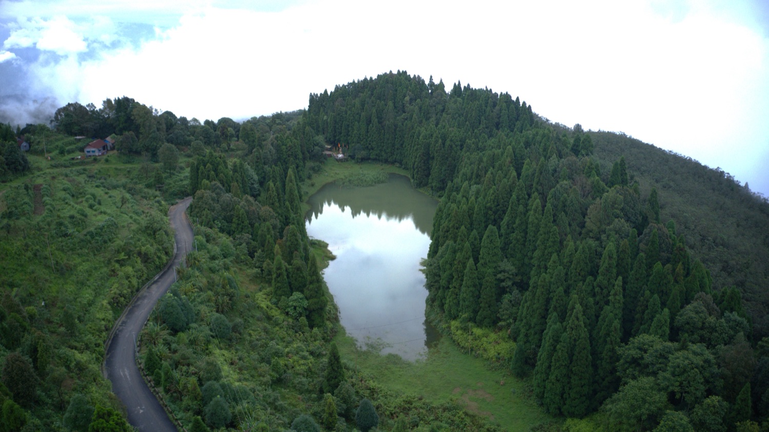 Aerial view of Namthing (Selpu) Pokhri, a hill pond ringed by forest
